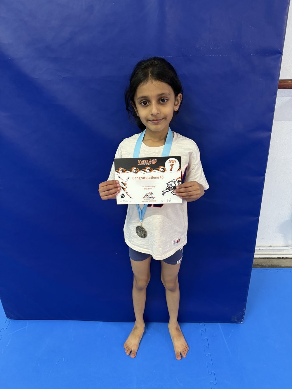 A gymnast with her Katleap award certificate