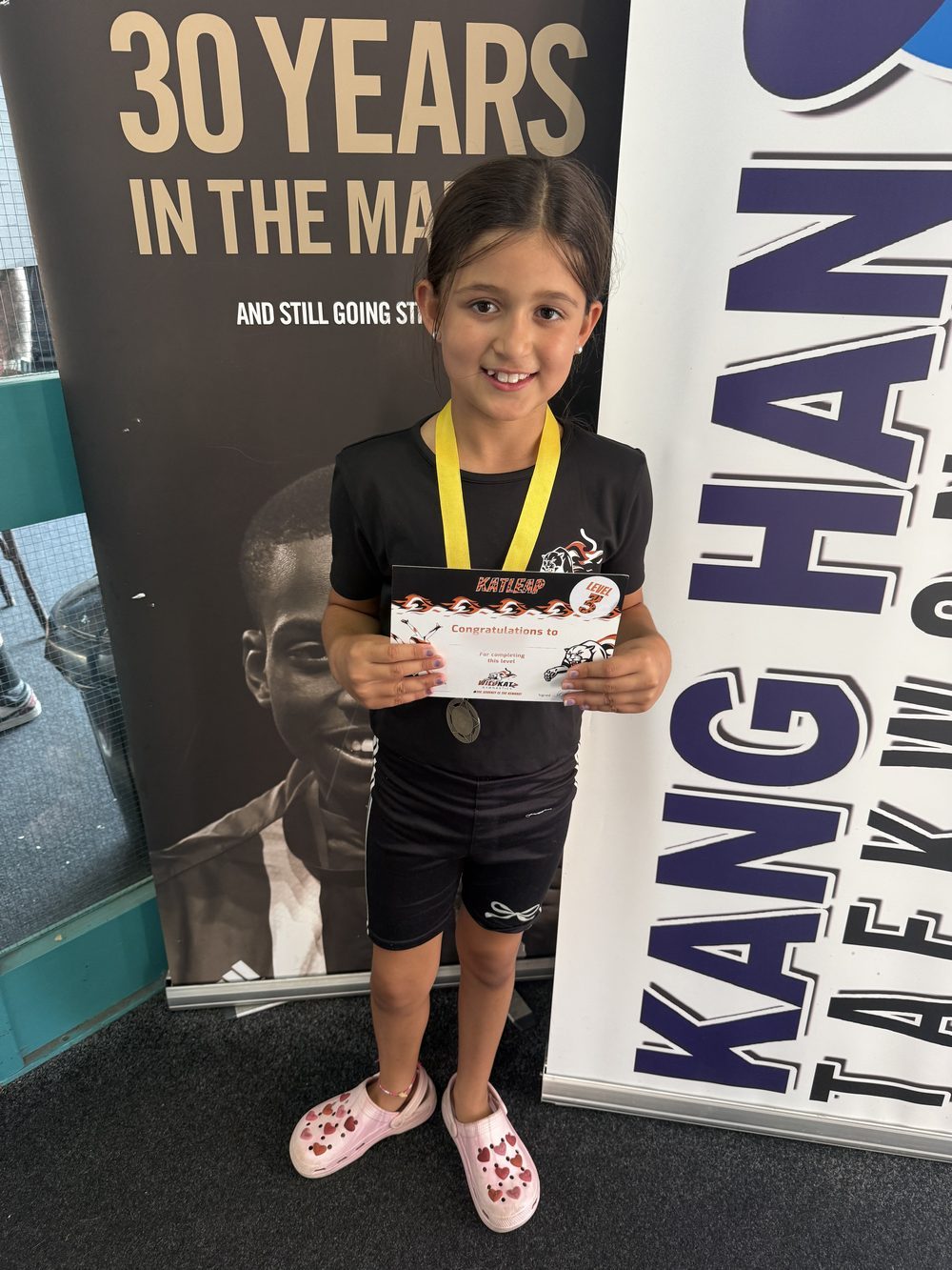 A gymnast with her Katleap award certificate